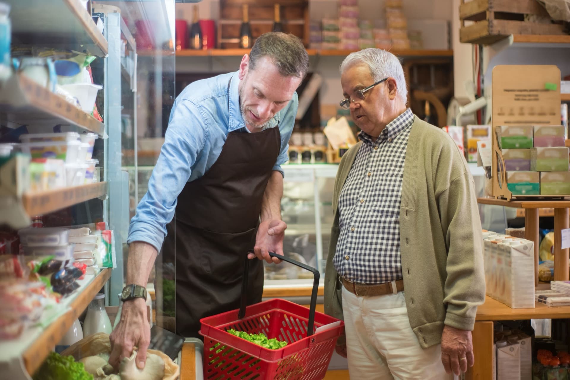 Store vendor and specialty grocer reviewing product together in a retail cooler